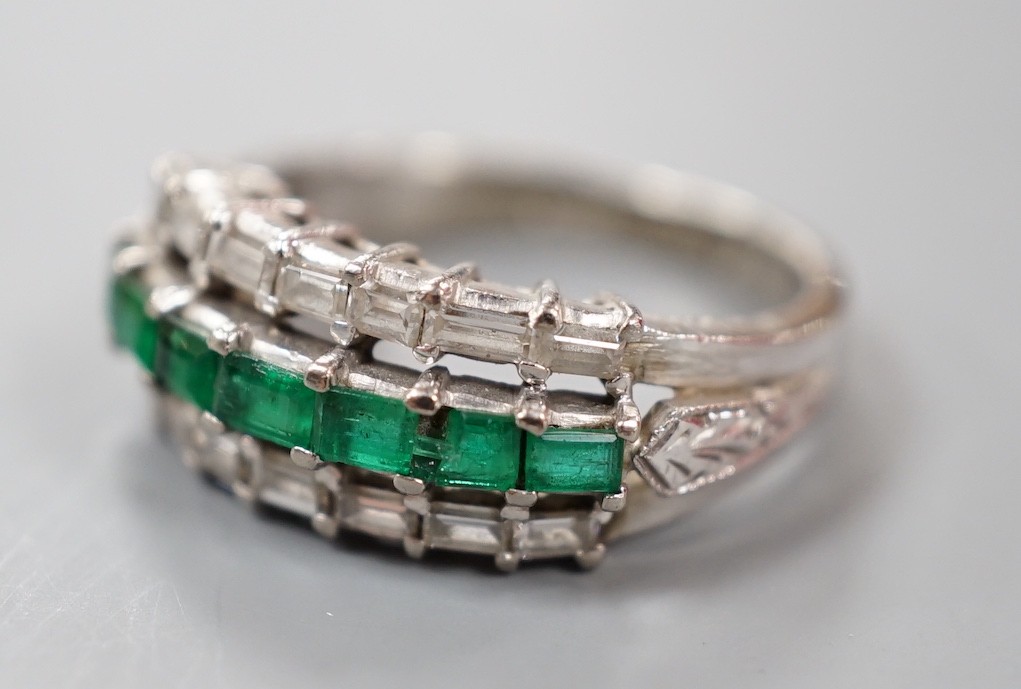 A modern 18k white metal, emerald and baguette cut diamond set three row half hoop ring (shank cut), size L, gross weight 5 grams.